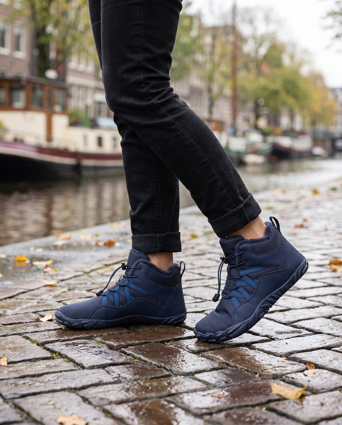 Dijk winterboot gedragen buiten op natte kinderkopjes langs de gracht