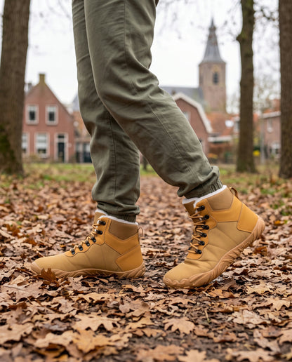 Heide winterboot gedragen buiten op een bospad vol eikenbladeren